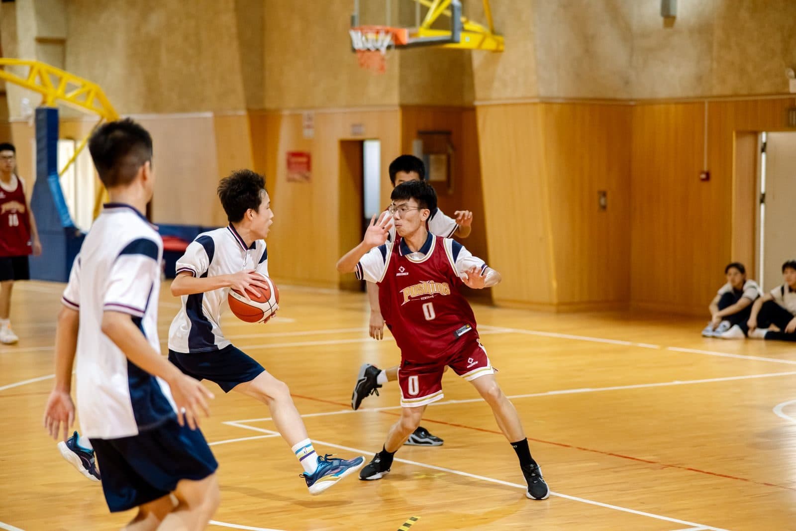 Youth basketball players guarding the ball during an indoor game